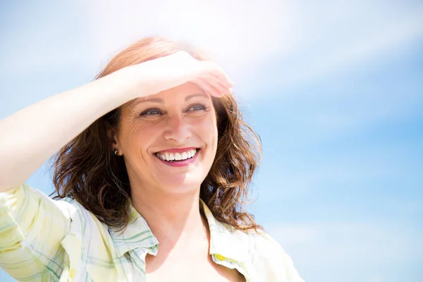 Счастливая женщина средних лет защищает от солнца — стоковое фото