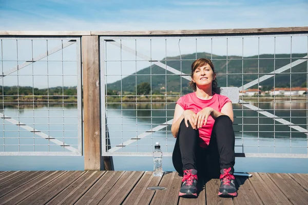 Donna di mezza età rilassante dopo la corsa — Foto Stock