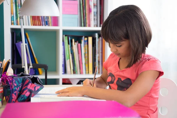 Молодая девушка делает домашнюю работу — стоковое фото