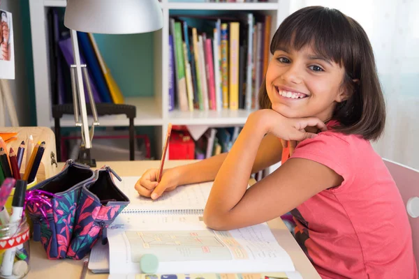 Happy schoolgirl doing homework — Stock Photo, Image