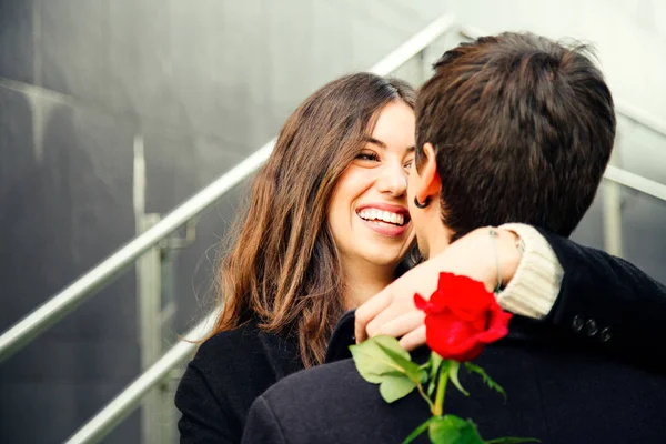 Happy couple in love with a rose on the street — Stock Photo, Image