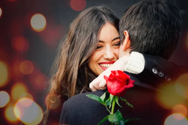 Šťastný pár v lásce s růží všeobjímající na ulici — Stock fotografie