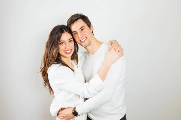 Šťastný mladý pár objímat na bílém pozadí — Stock fotografie