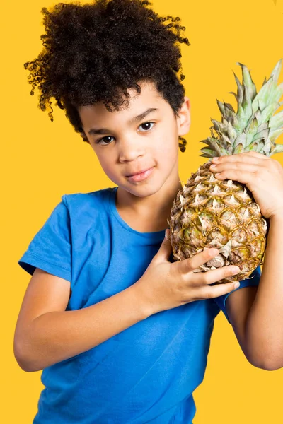 Süßer kleiner Junge mit einer Ananas auf der Schulter — Stockfoto
