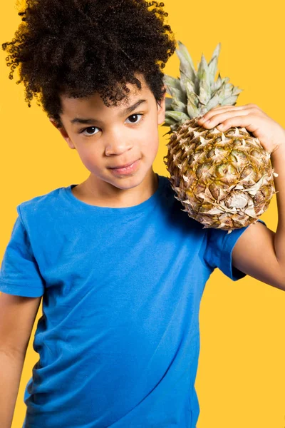 Süßer kleiner Junge mit einer Ananas auf der Schulter — Stockfoto