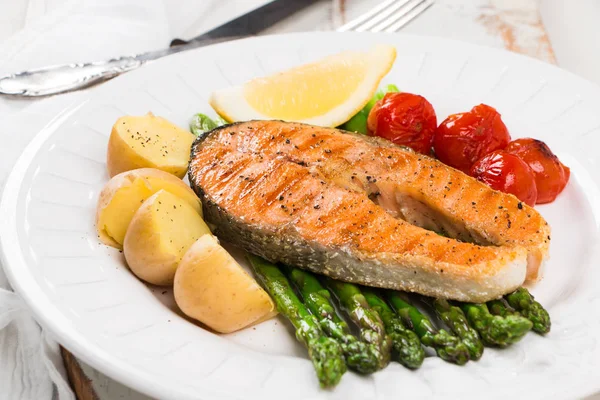 Saumon grillé aux asperges vertes, tomates cerises et pommes de terre — Photo