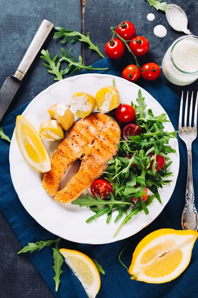 Grilled salmon with arugula and cherry tomato salad and potatoes — Stock Photo, Image