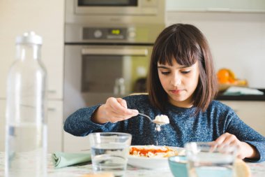 Küçük kız onu makarna yemek peynir yayılan