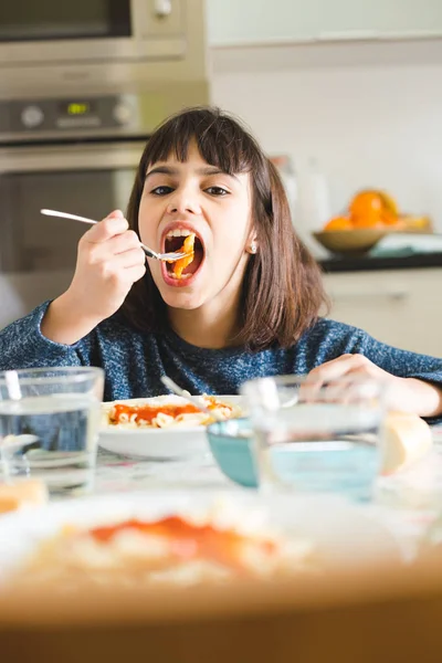 Маленькая девочка наслаждается своим блюдом из макарон — стоковое фото