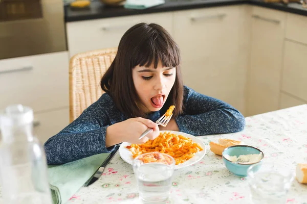 Маленька дівчинка їсть макарони вдома — стокове фото