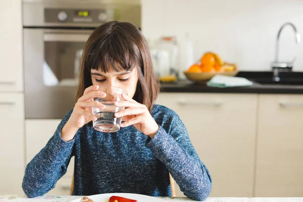 Niedliches durstiges Mädchen trinkt zu Hause Wasser im Glas — Stockfoto