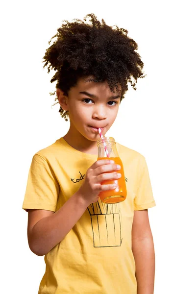 Schattige kleine jongen drinken sinaasappelsap met een rietje — Stockfoto