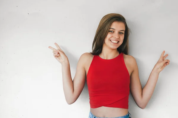 Happy and cute teen girl making victory sign — Stockfoto