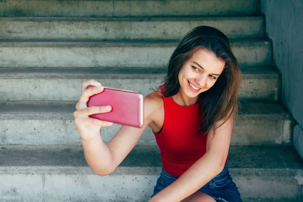 Ragazza adolescente compiaciuta in posa per un selfie seduto sulle scale — Foto Stock