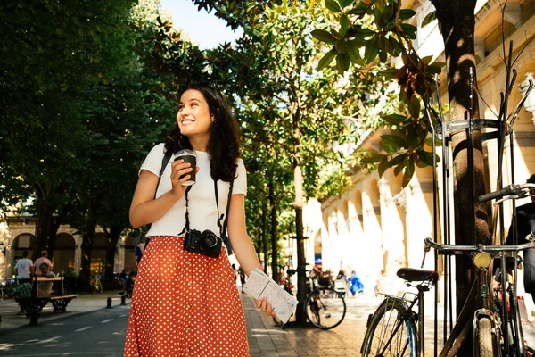 ヨーロッパの街を訪れながらコーヒーを飲んでいる幸せな観光客の女性 — ストック写真