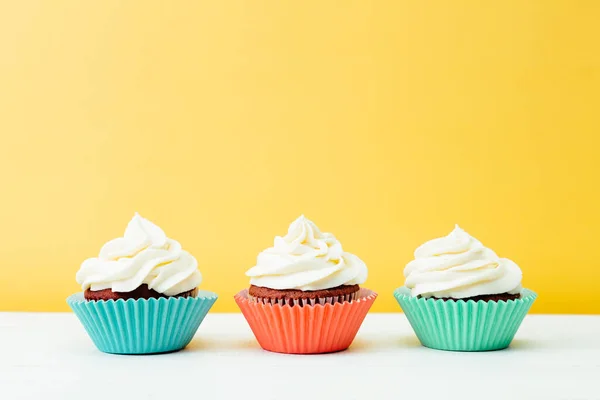 Três Cupcakes Veludo Vermelho Colorido Fundo Amarelo — Fotografia de Stock