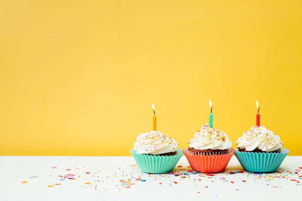 Tres Cupcakes Cumpleaños Coloridos Con Velas Confeti Sobre Fondo Amarillo —  Fotos de Stock