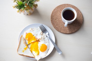 Sabah kahvaltıda iki yumurta ve portakal sarısı, kızarmış ekmek ve sade kahve..