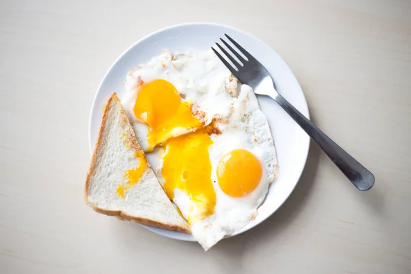 Dois ovos fritos com gemas de laranja, pão torrado pela manhã para o café da manhã . — Fotografia de Stock