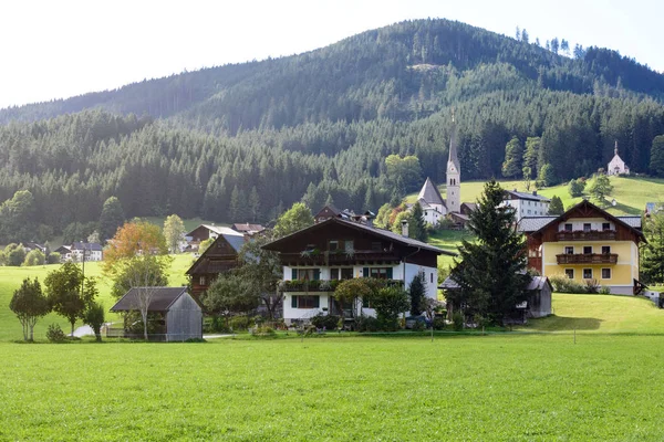 Avusturya 'da sabah erken saatlerde. Geleneksel Avusturya manzarası: dağlar, rahat evler ve yeşil çimenler. Avrupa gezisi. Sakinlik ve istikrar hissi. — Stok fotoğraf