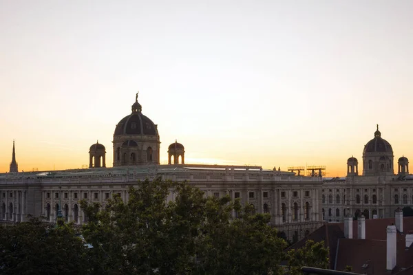 Avusturya 'nın Viyana şehrinde gün doğumu. Güneşin doğuşunda eski bir binanın kubbeleri. Yeni bir günün başlangıcı. — Stok fotoğraf