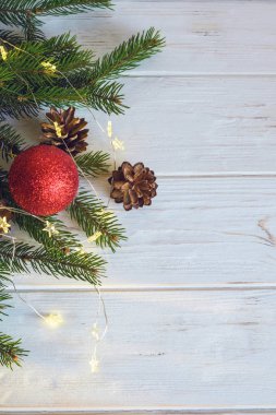 Kırmızı Noel oyuncağı, ladin dalları ve kozalaklar yeni yıl havası yaratır. Mutlu Noeller ve mutlu yıllar konsepti. Bulanık.