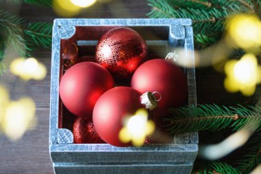 Kırmızı Noel oyuncağı, ladin dalları ve kozalaklar yeni yıl havası yaratır. Mutlu Noeller ve mutlu yıllar konsepti. Bulanık.