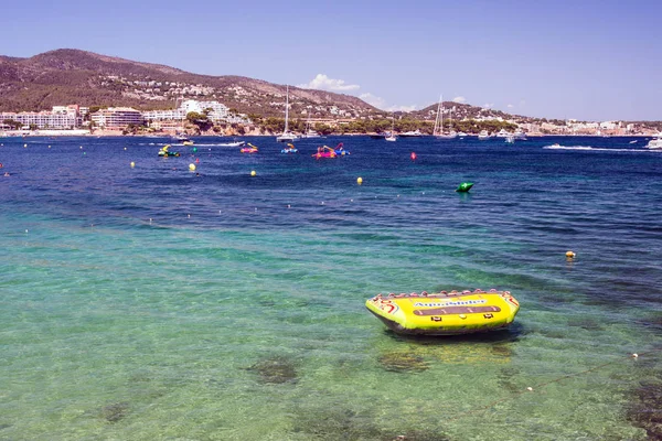 Palma Nova, Mallorca, julio 2019. Barco inflable amarillo para turistas de entretenimiento acuático. Hermosas vistas al mar, el cielo y los turistas. Descanso Islas Baleares . — Foto de Stock