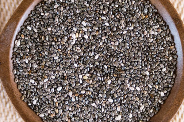 Sementes comestíveis de chia, Salvia hispanica, uma planta com flores da família da hortelã. Um produto alimentar saudável popular . — Fotografia de Stock