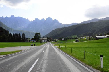 Hallstatt, Avusturya, Eylül 2019. Avusturya 'da sabah erken saatlerde. Geleneksel Avusturya manzarası: dağlar, yol, rahat evler ve yeşil çimenler. Avrupa gezisi. Sakinlik ve istikrar hissi.