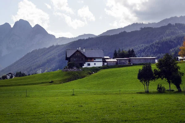 オーストリアでの早朝。伝統的なオーストリアの風景:山、居心地の良い家や緑の芝生。ユーロ旅行。落ち着きと安定感. — ストック写真