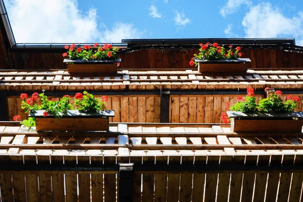 Hallstatt, Oostenrijk. Beroemd bergdorpje in de Oostenrijkse Alpen op een warme herfstdag. Traditionele Oostenrijkse houten huizen met bloemen versierde balkons — Stockfoto