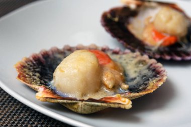 Peynirli ve baharatlı soslu fırında istiridye. Narin midye gerçek bir zevktir. İspanyol balık restoranında romantik bir akşam yemeği. Mallorca Adası, İspanya.