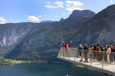 Hallstatt, Avusturya, Eylül 2019. Turistler Skywalk platformunda fotoğraf çekiyorlar. Avusturya 'nın Hallstatt, göl ve dağlarındaki gözlem güvertesinden güzel manzaralar..