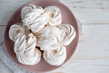 Pembe bir tabakta el yapımı beyaz ev yapımı şekerlemeler. Beyaz arkaplan.