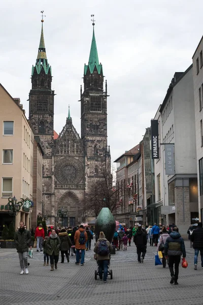 Norimberk, Německo, leden2020. Středověký kostel sv. Lorenze. Turisté procházka k památkám v zamračený den. — Stock fotografie