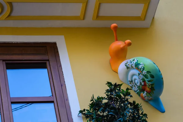 Caracol gracioso en el balcón contra el fondo de una pared amarilla. Una figura interesante en el balcón español de la ciudad de Valencia, España. Vestidor de balcones . — Foto de Stock
