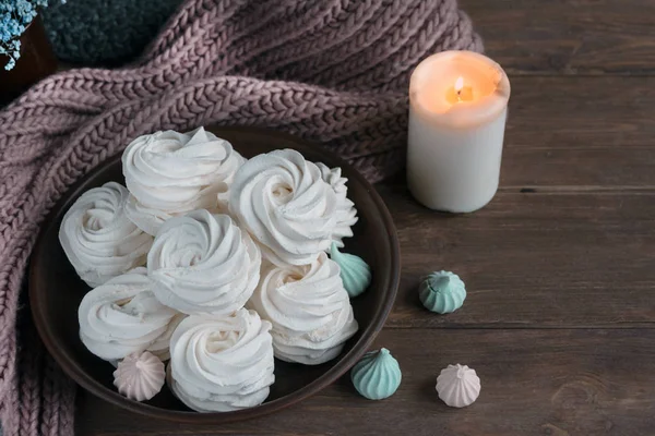 Handmade apple white homemade marshmallows on a brown plate and coffee in a black mug on a wooden table. Sweet zephyr and aromatic coffee. — Stock Photo, Image