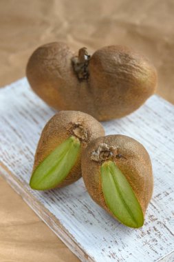 Beyaz tahtada ve el işi kağıdında büyük çirkin sebzeli organik kivi. Yatay oryantasyon. Çirkin yemek konsepti. Yakın plan..