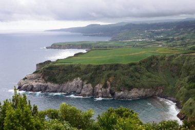 Deniz üzerinde büyük gök gürültülü bulutlar ve Portekiz takımadalarındaki San Miguel adasının merkezinde kayalıklar. Azores 'e git..