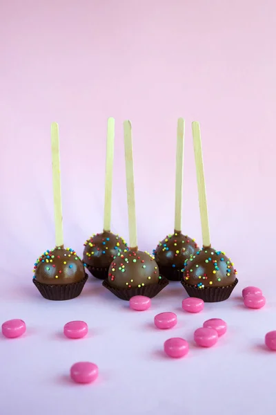 带有椰子片的巧克力蛋糕在粉红的背景上爆出 木棍上的小蛋糕 一种受欢迎的甜甜点 — 图库照片