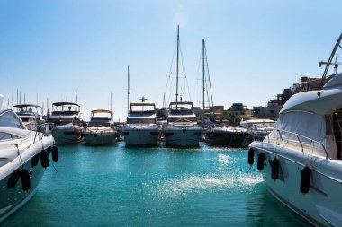 Kıbrıs Rum Kesimi 'nin Limasol Marina limanında mavi gökyüzüne karşı lüks beyaz yatlar.