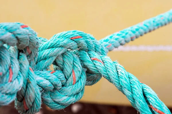 Sarı arka planda eski yeşil bir ip var. Düğüm. Çözülemeyen problem kavramı