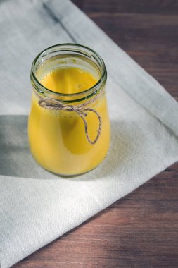 Süt ve biberli beyaz keten peçeteye, sağlıklı bir süt ve sütle dolu cam kavanoz. Hastalıkların ve virüslerin önlenmesi.