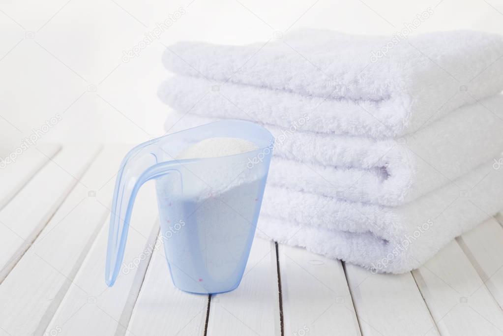 Bath towels and washing powder in measuring cup