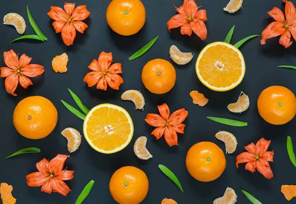 Olika citrusfrukter och orange liljor på svart bakgrund — Stockfoto
