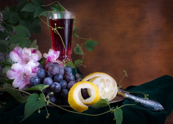 Copo de vinho, flores cor de rosa, uvas e limão — Fotografia de Stock