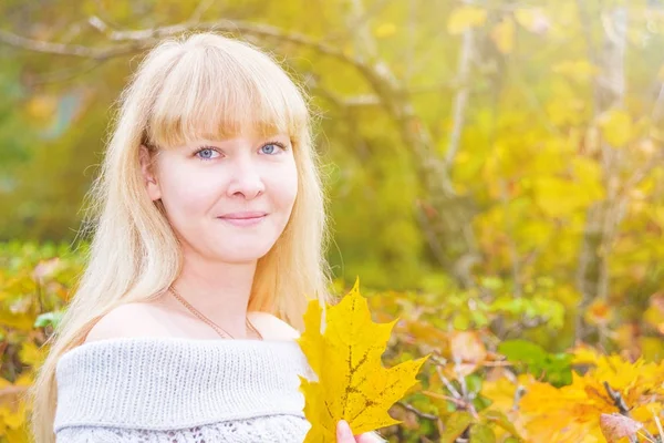 Blonde blauwogige in een herfst park — Stockfoto