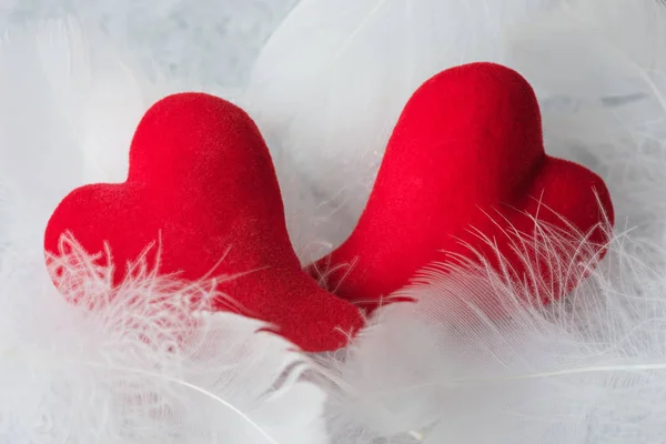 Deux coeurs rouges reposent sur des peluches blanches — Photo