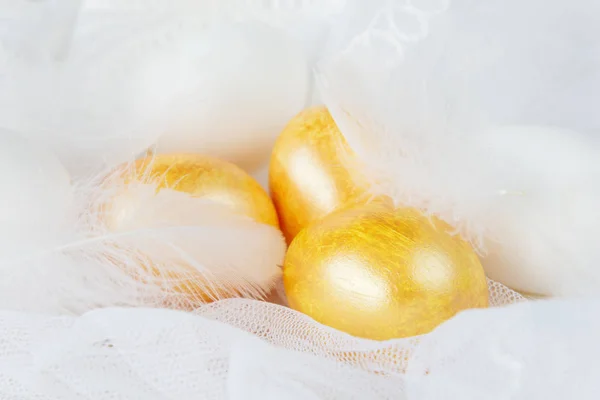 Golden Easter eggs end white feathers — Stock Photo, Image